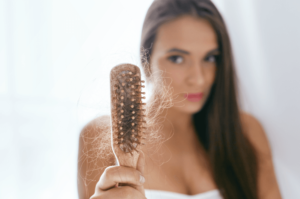 mujer con perdida de cabello en un peine