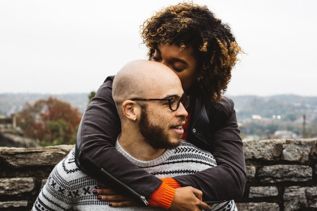 Un señor con alopecia androgénetica siendo abrazado por la esposa.