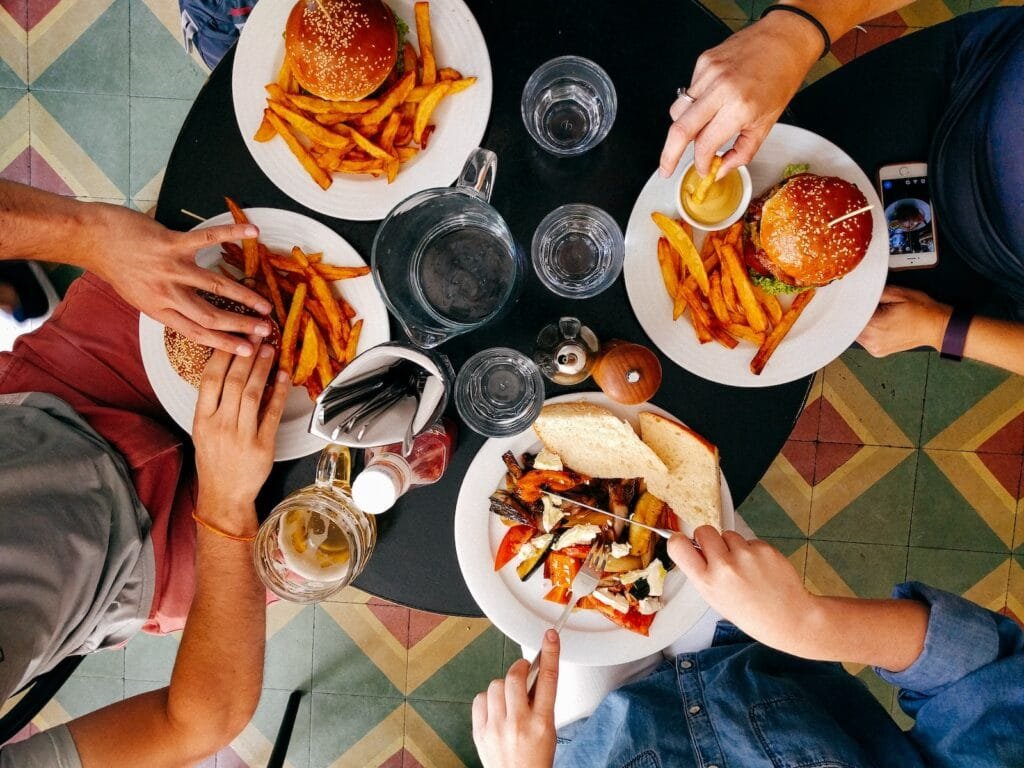 Cuatro personas comiendo alimentos que pueden acelerar la pérdida de cabellos