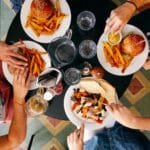 Cuatro personas comiendo alimentos que pueden acelerar la pérdida de cabellos